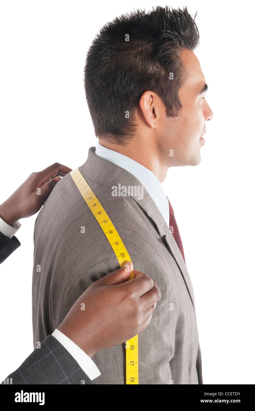 Tailor measuring across upper back from shoulder to shoulder of