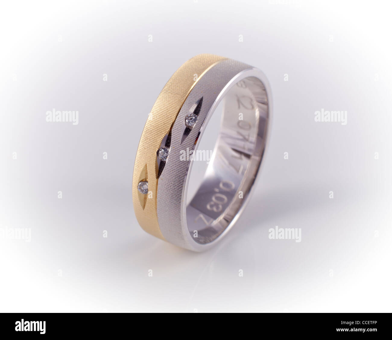 Wedding ring in yellow and white gold with diamonds. Stock Photo