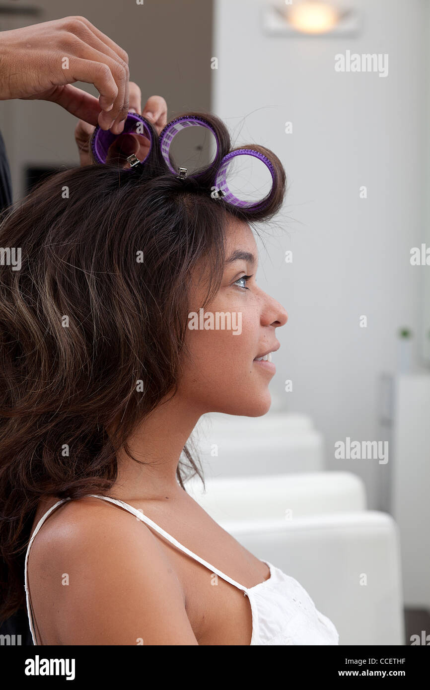 Side profile of young woman wearing curlers Stock Photo