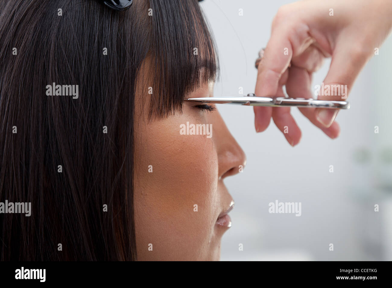 Close-up view of hairstylist cutting hair Stock Photo