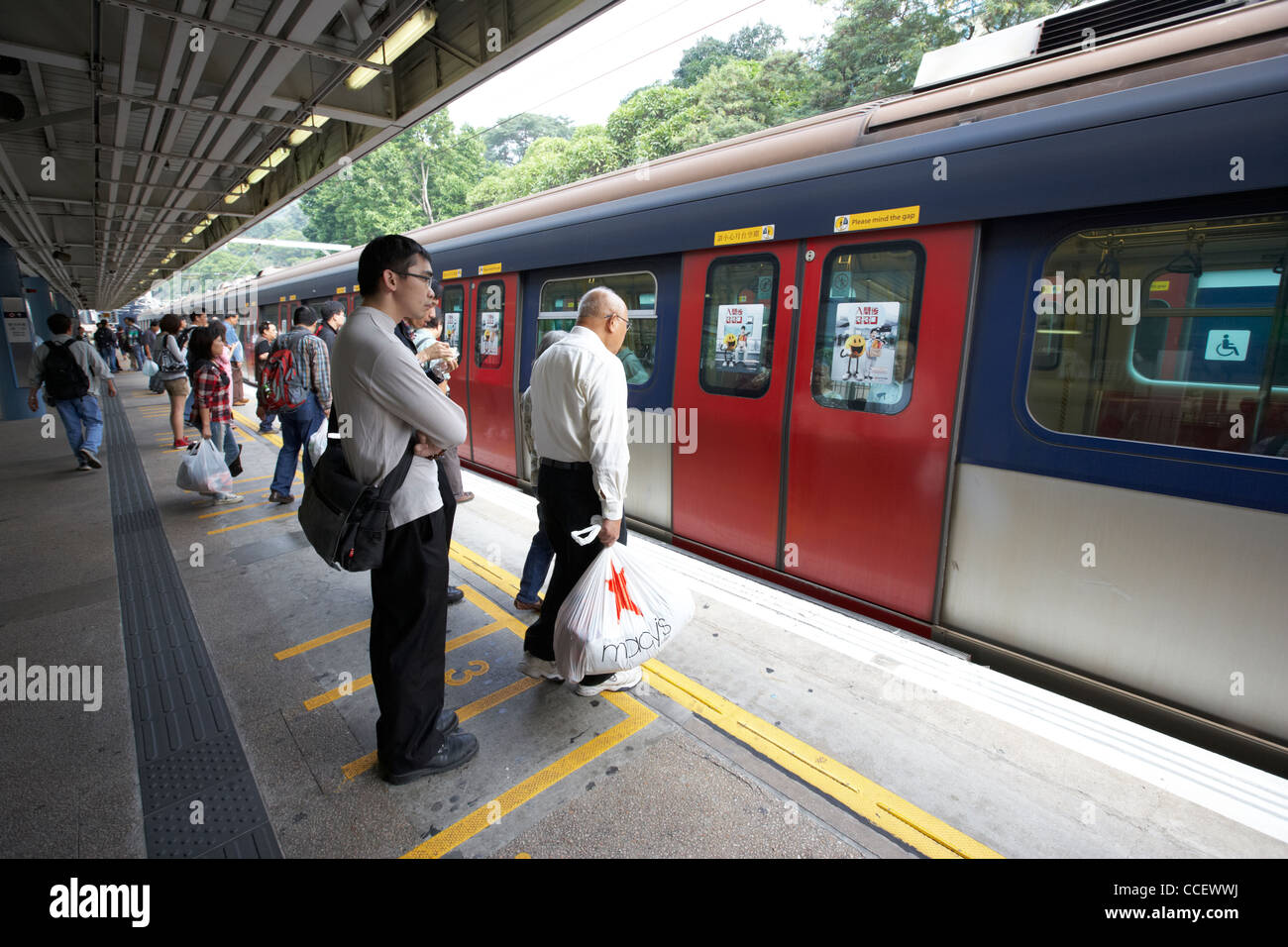 passengers waiting on the platform for train on mtr overground line