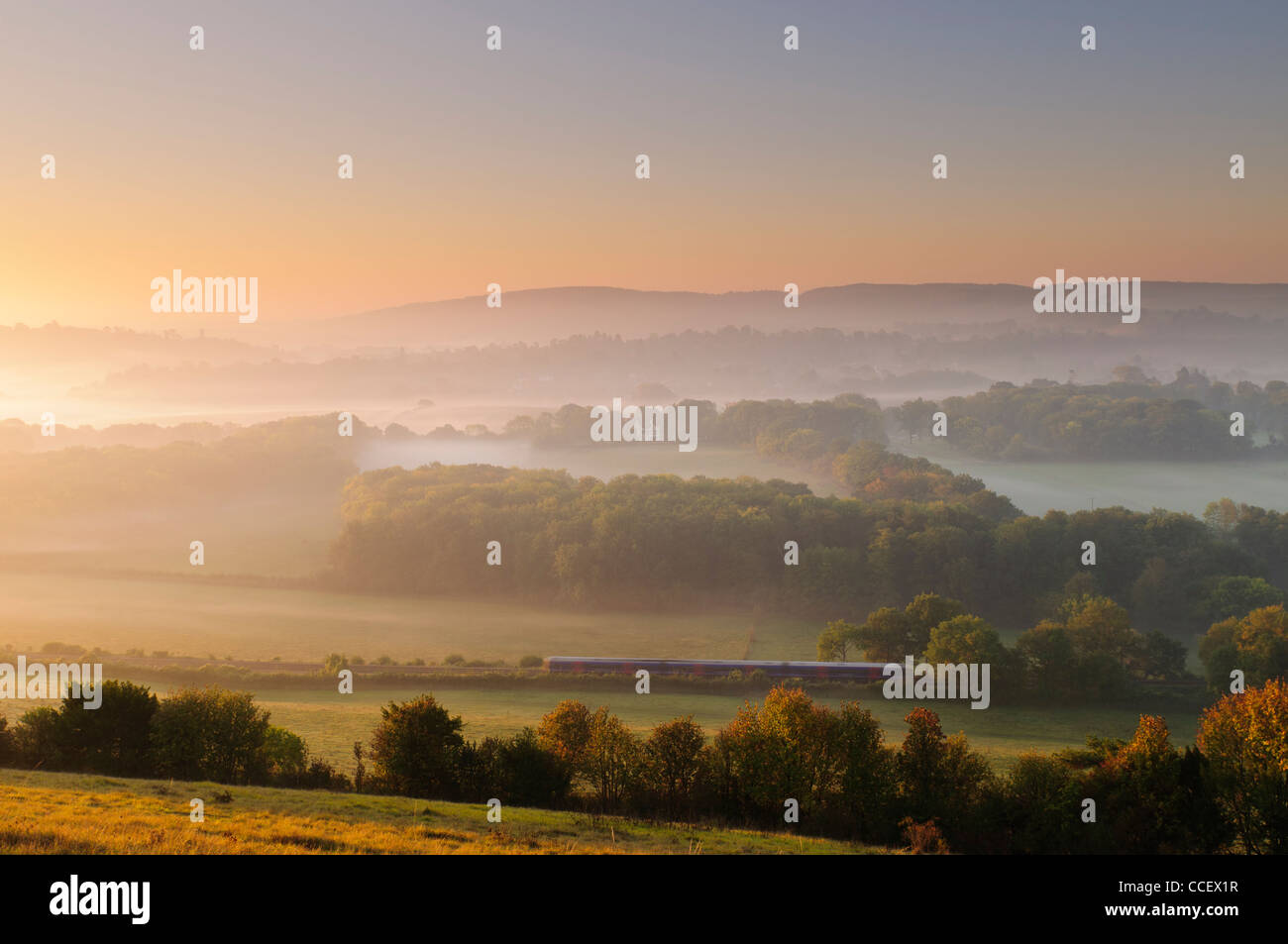 Early morning view from the edge of Ranmore Common, near Dorking in Surrey, UK. A train is heading towards Dorking direction. Stock Photo