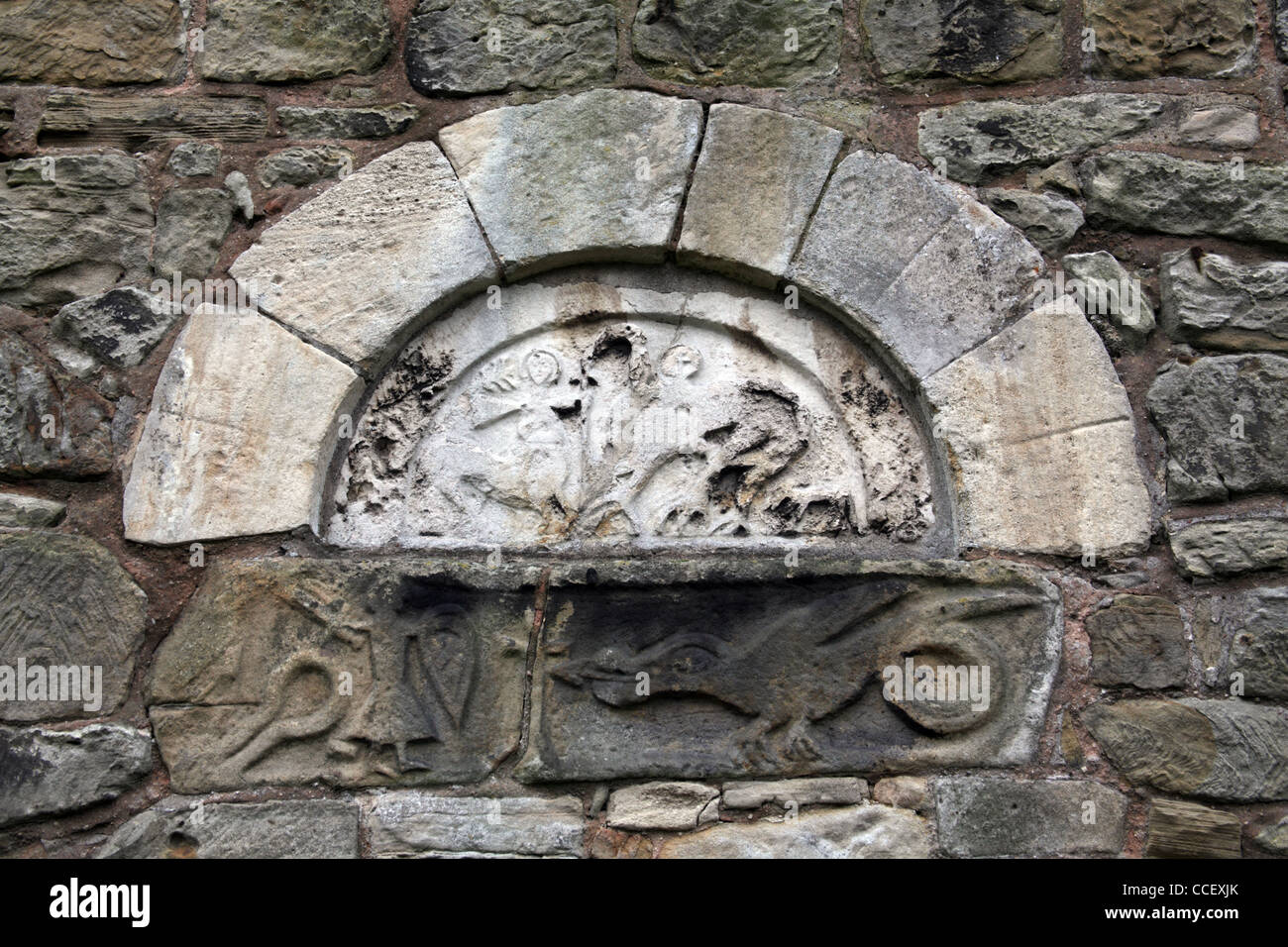 The blocked Anglo Saxon west doorway with carved tympanum, St John the Baptist Church, Ault Hucknell, Derbyshire Stock Photo