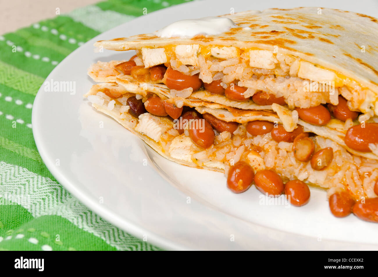 Chicken Quesadillas with Chili Beans, Sour Cream, Rice, and Cheese Stock Photo