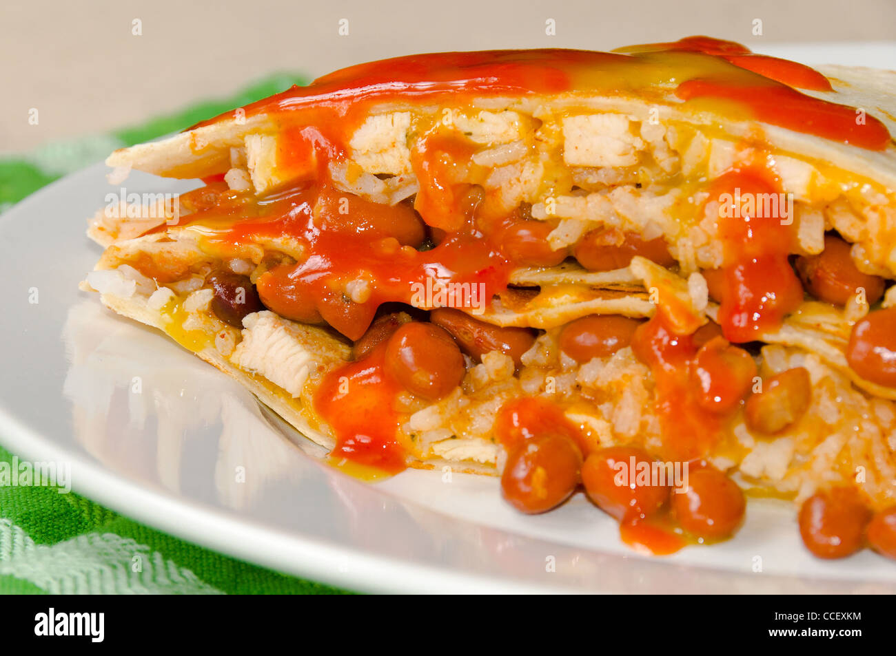 Chicken Quesadillas with Chili Beans, Sour Cream, Rice, Cheese, and Red and Green Hot Sauce Stock Photo