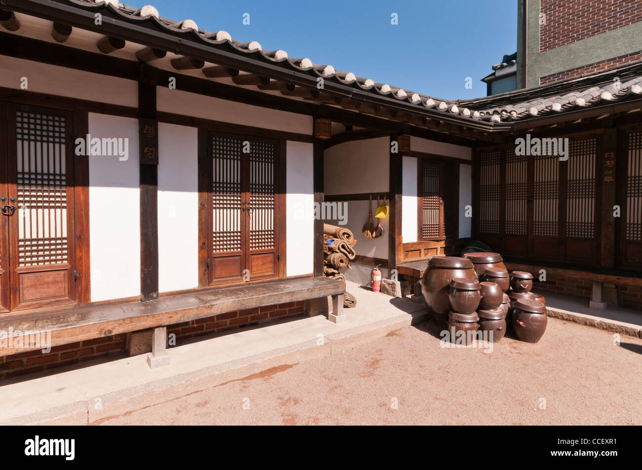 Hanok (Korean traditional house with timber frames and clay tiles) and its courtyard.  Clay pots are on display. Seoul, Korea Stock Photo