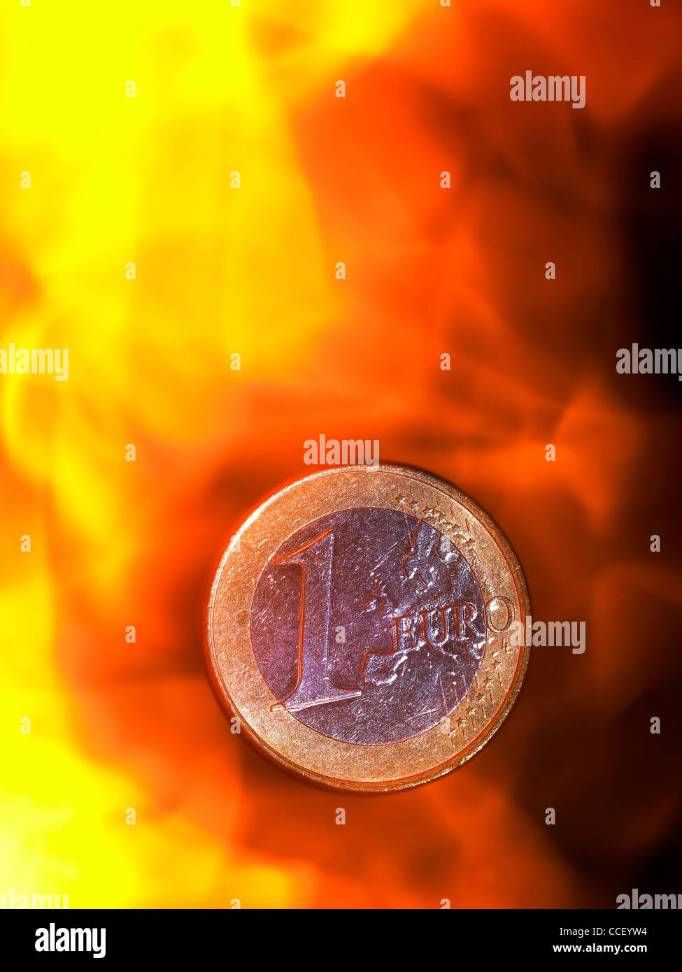 A one euro coin amongst flames Stock Photo