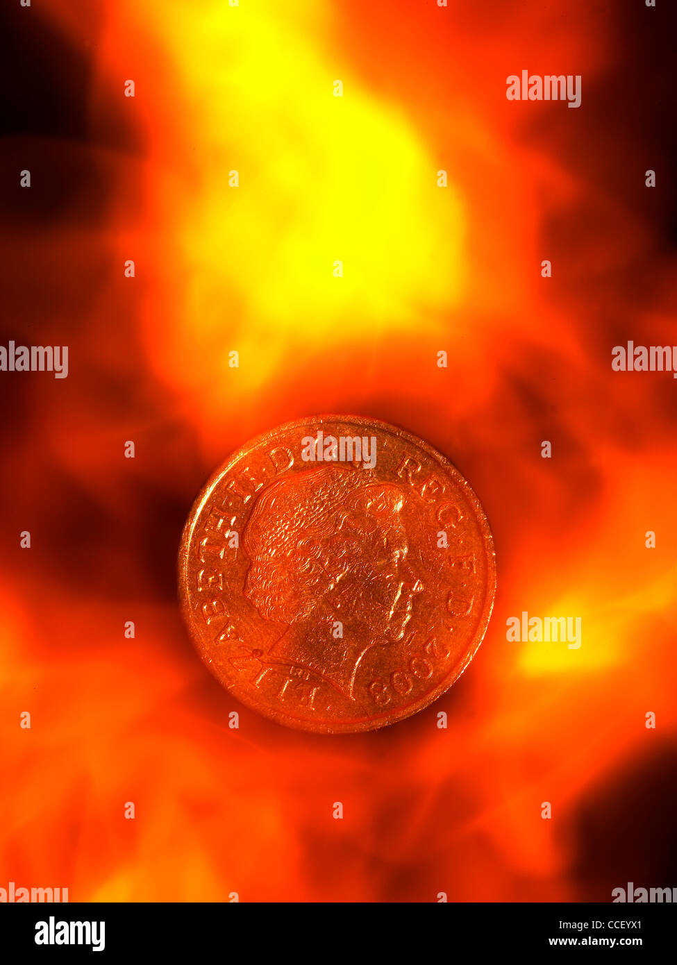 A one pound coin amongst flames Stock Photo