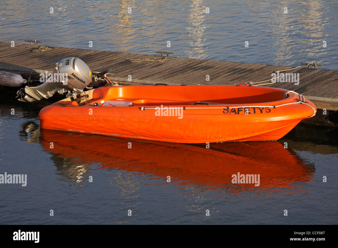 Safety5 - orange safety boat tied up alongside jetty at Poole Yacht Club in December Stock Photo