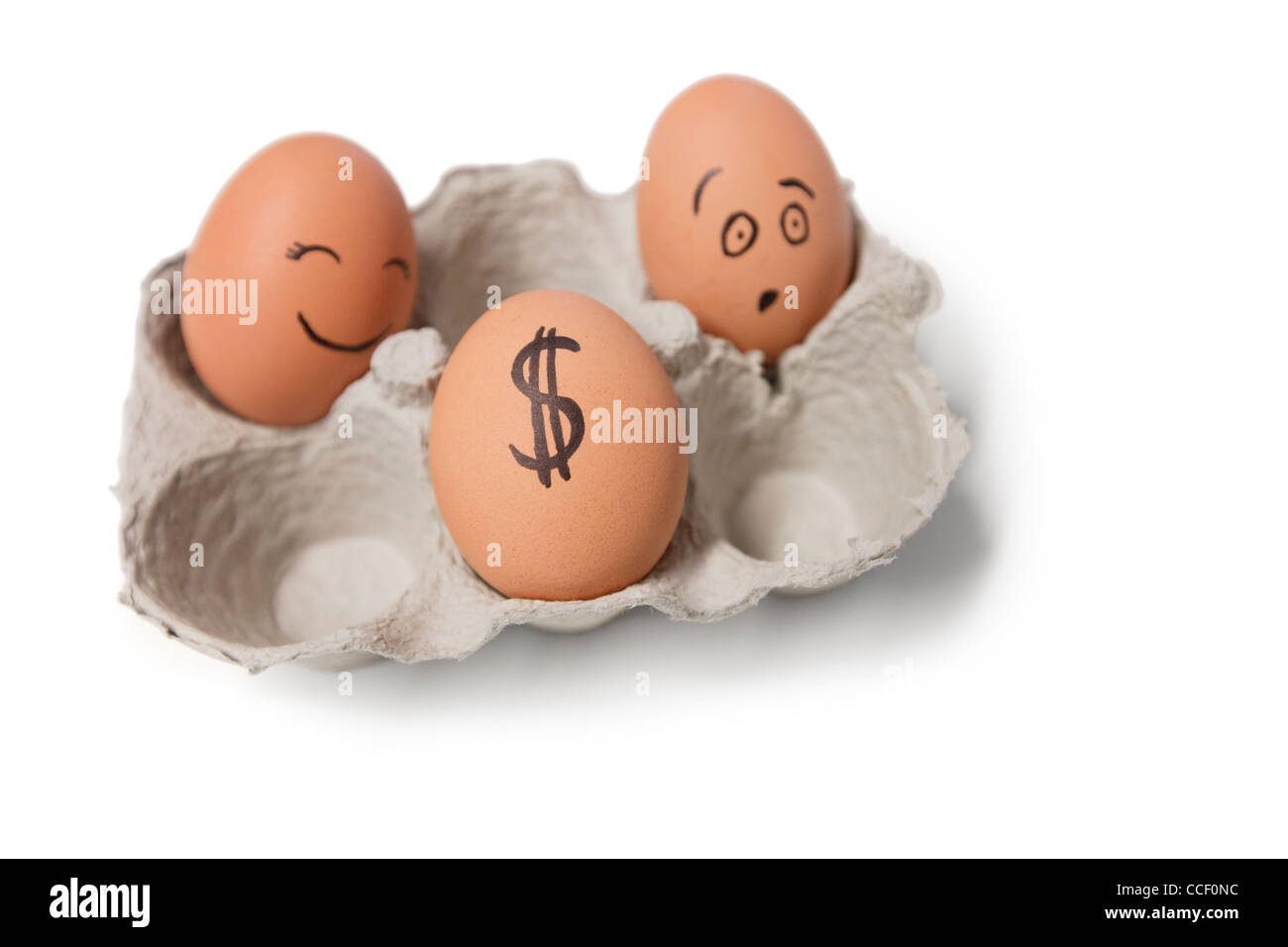Three eggs in carton with a dollar sign on one egg Stock Photo