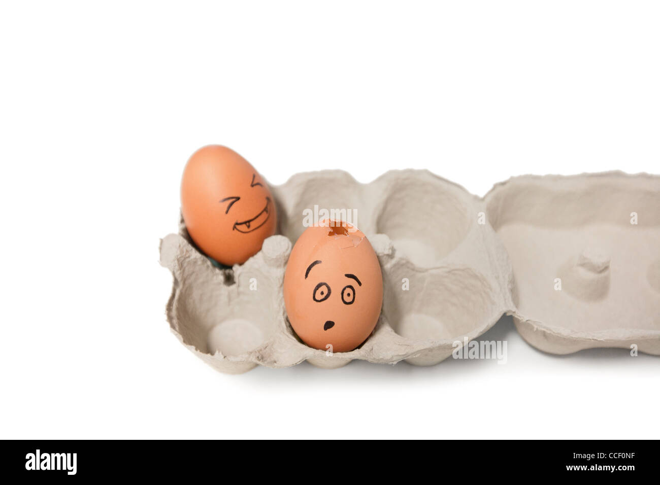 Carton of brown eggs with one cracked egg Stock Photo
