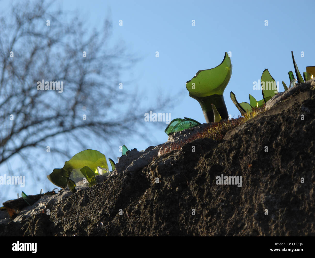 broken glass used as a burglar intruder deterrent on high wall Stock Photo