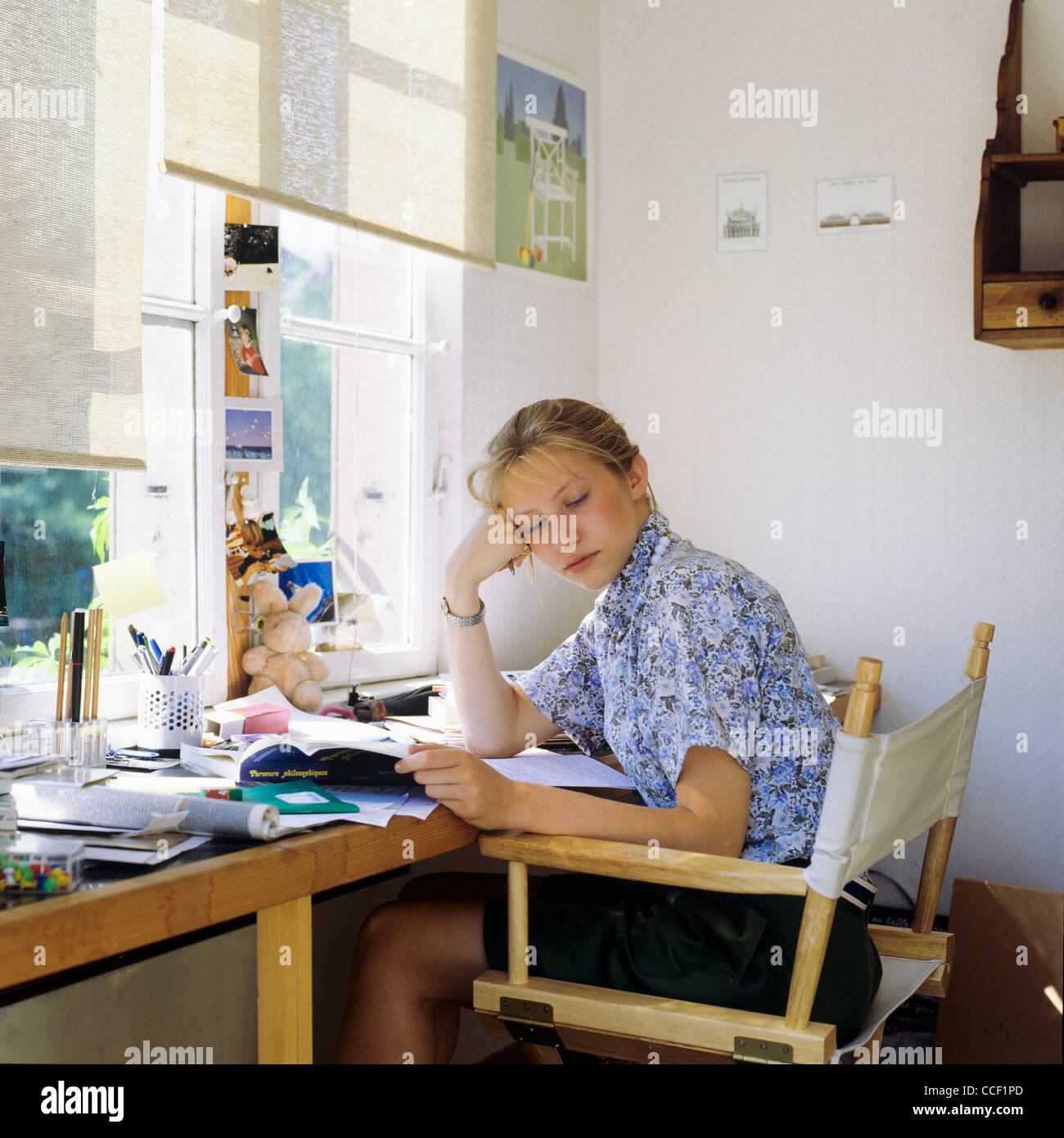 MR Sleepy teenage girl doing her school homework Stock Photo