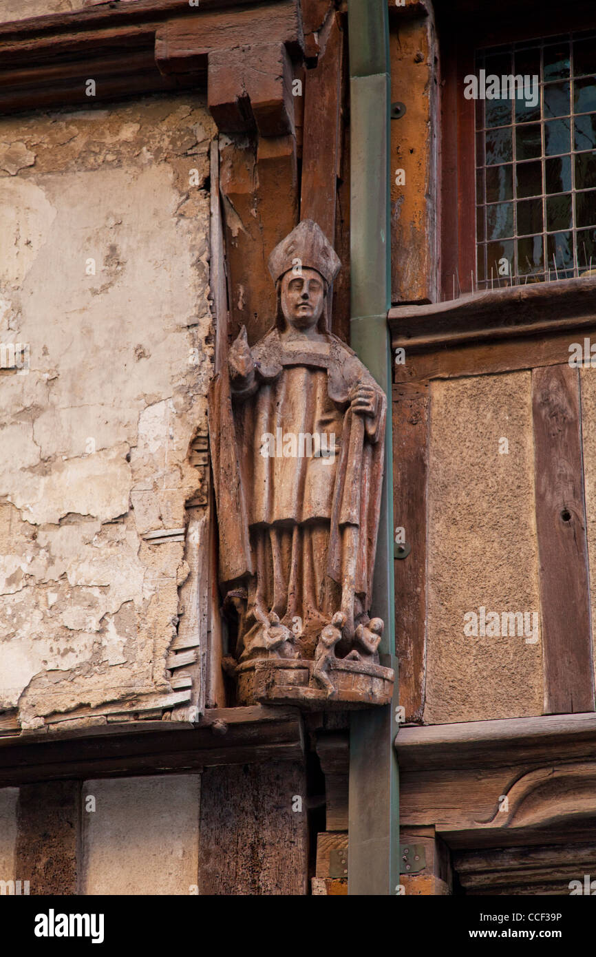 Clerical figure on old house in the medieval town of Dinan, Brittany, France. Stock Photo