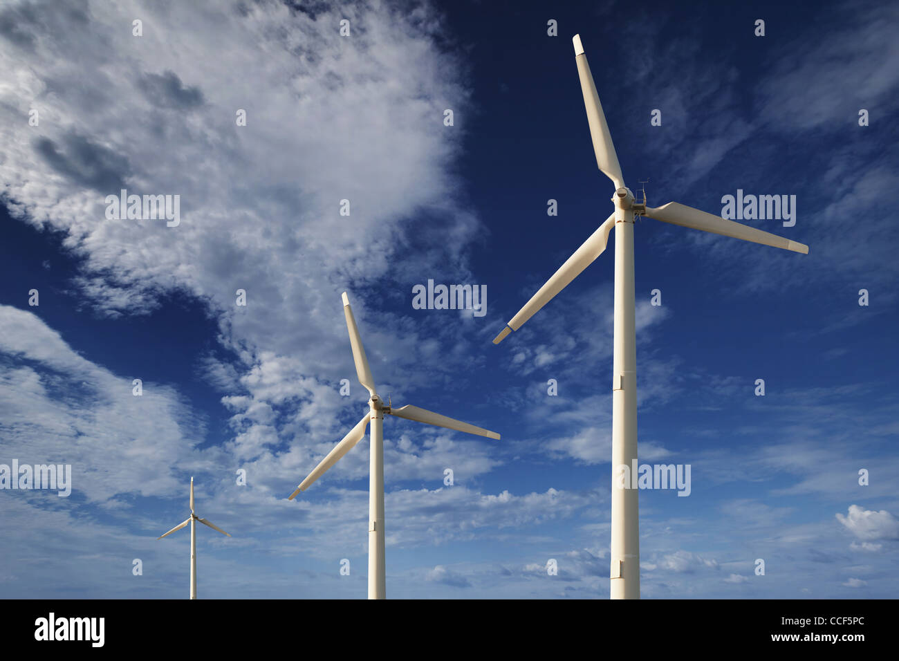 Wind turbines against a blue sky with clouds Stock Photo - Alamy