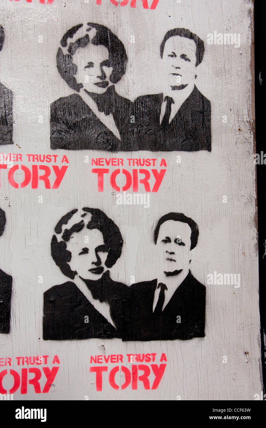 'Never Trust a Tory' stencil poster art with Prime Ministers Thatcher and Cameron on boarded-up derelict pub Cardiff Wales UK Stock Photo