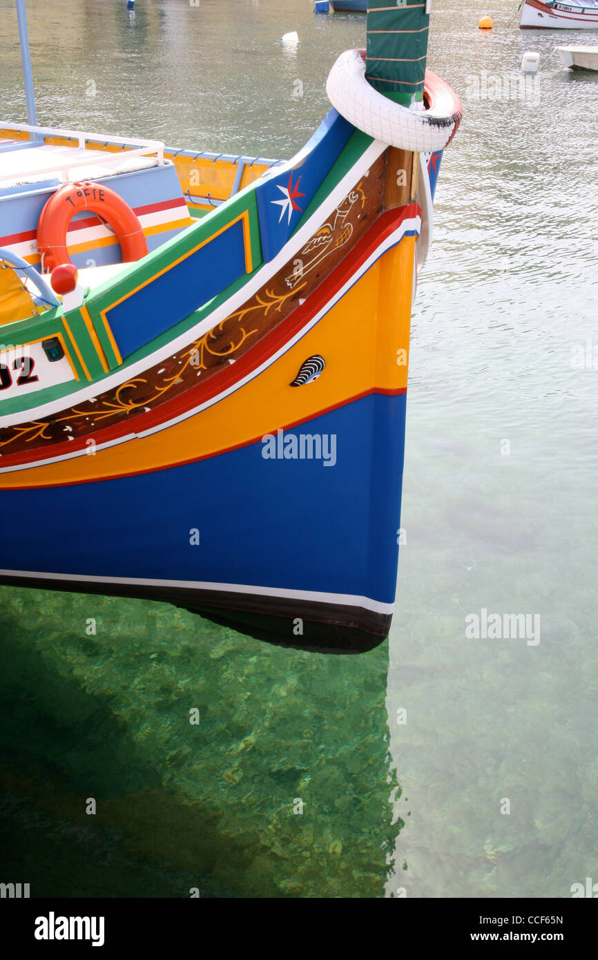 Luzzu boat in clear water at Bugibba Malta Stock Photo