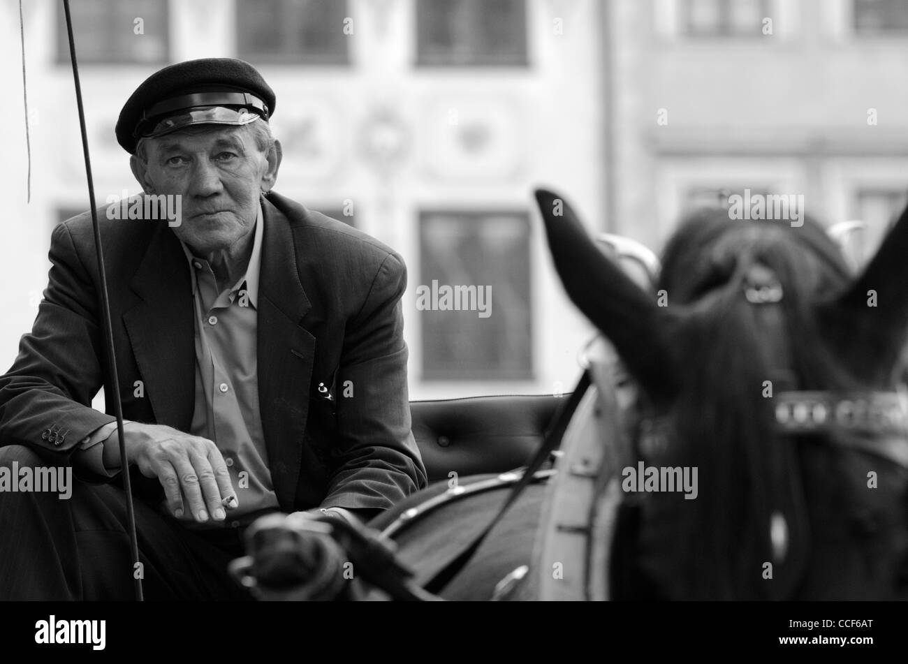 Coachman takes a cigarette break when waiting for the next passengers in Old Town Market Place, Warsaw, Poland Stock Photo