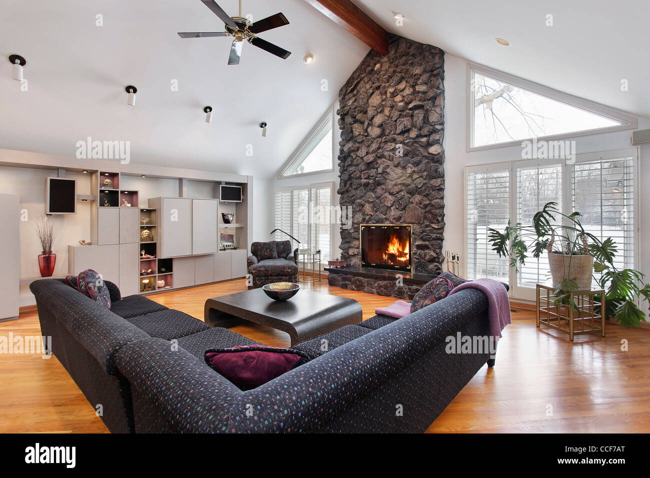 Family room with two story stone fireplace and wood beams Stock Photo