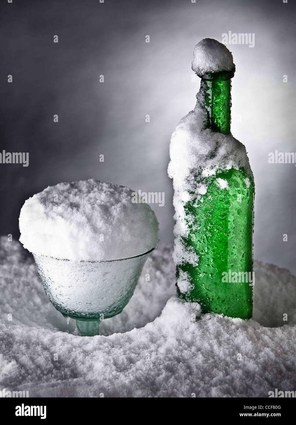 glass and bottle covered with snow ice cold drink conceptual art Stock Photo