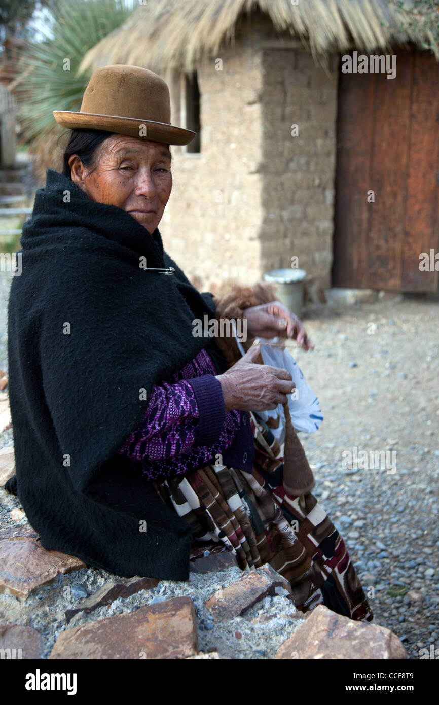 An Aymara woman weaves on a traditional hand loom in Huatajata on the Bolivian shore of Lake Titicaca. Stock Photo