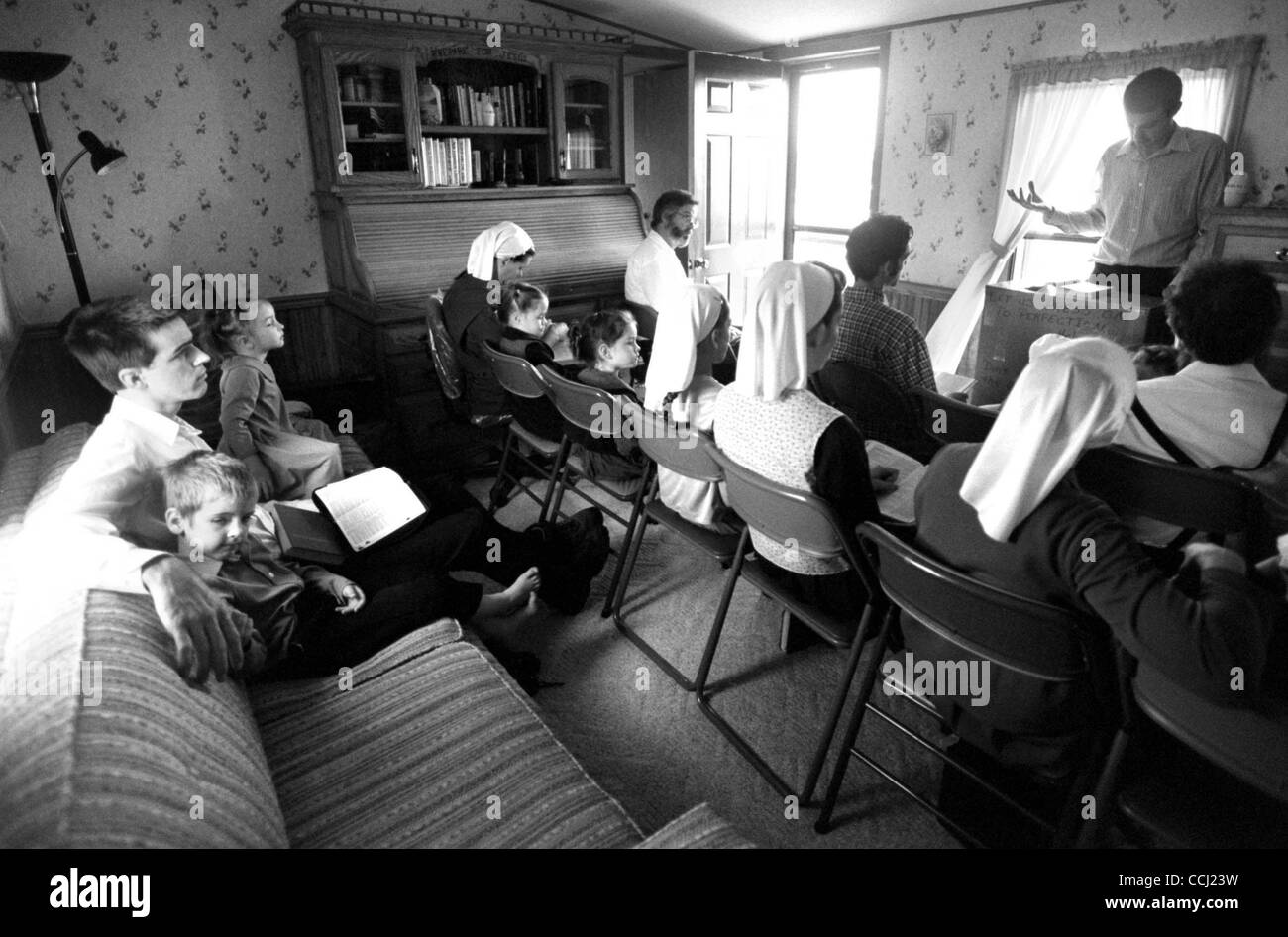 Jul. 22, 2003 - Arthur, Illinois, U.S. - DANIEL HELMUTH sits with his son SAMUEL HELMUTH, at left, during a Sunday service attended by other excommunicated Amish in his brother Paul's, home. The Old Order has excommunicated and shunned many of its members due to disagreements on acceptable practices Stock Photo