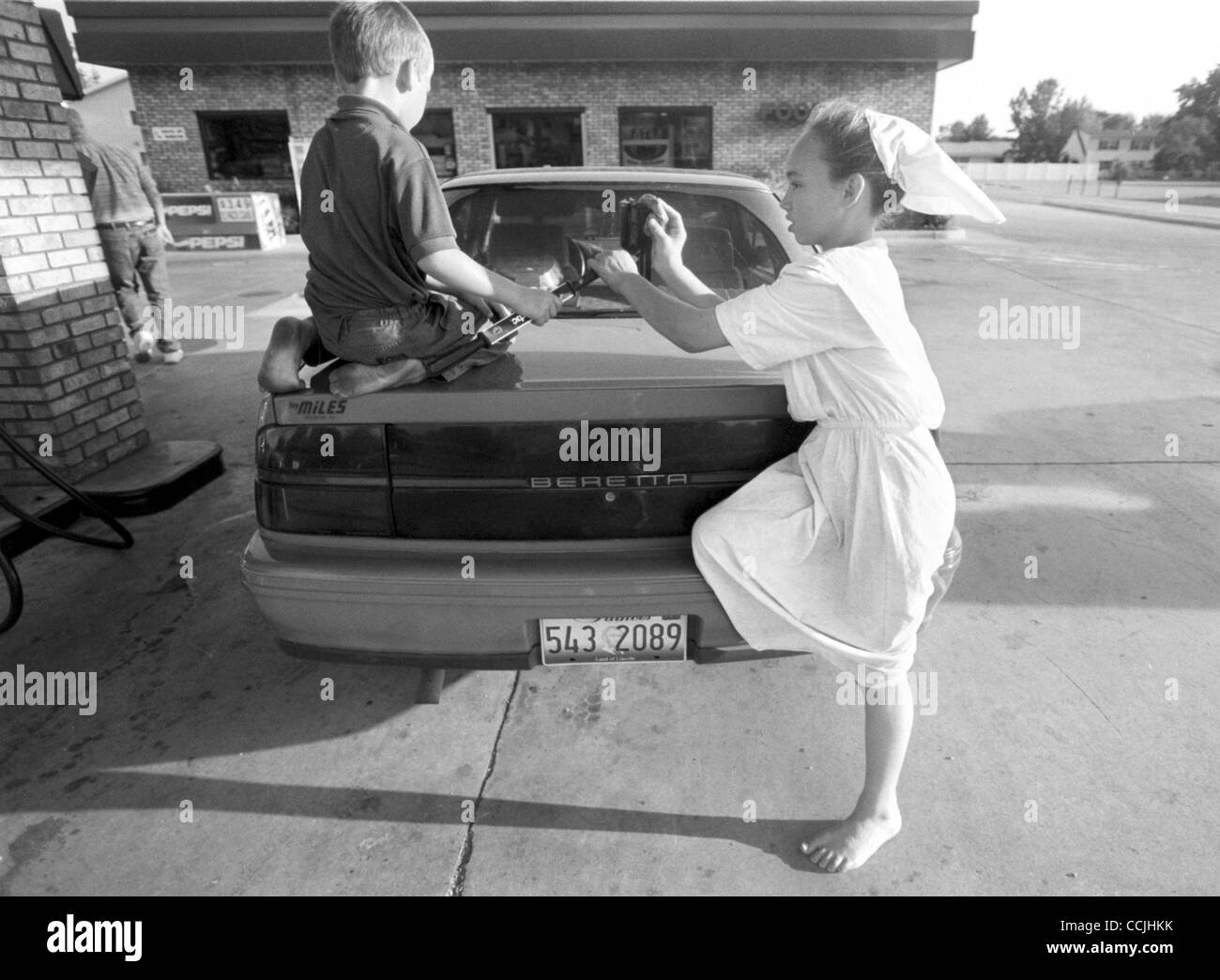 Aug. 12, 2003 Arthur, Illinois, U.S. Two Amish youths clean their father's car at a gas