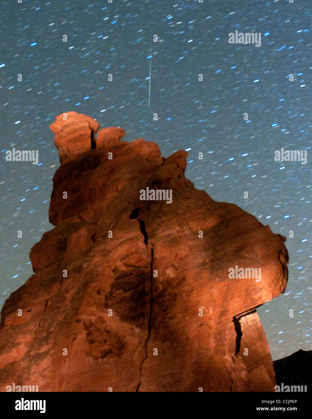 Dec 14, 2010 - VALLEY OF FIRE Nevada PARK, NV - , USA - A Geminid meteor streaks above one of the peaks of the Seven Sisters rock formation early December 14, 2010 in the Valley of Fire State Park in Nevada. The meteor display, known as the Geminid meteor shower because it appears to radiate from th Stock Photo