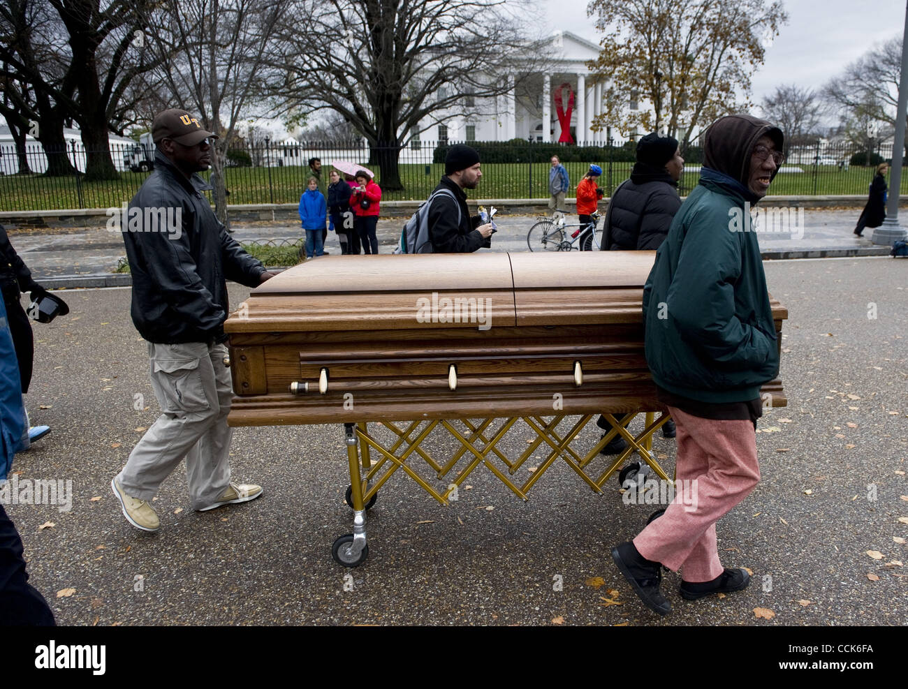 A group of people push a casket and gather in front of the White House to bring awareness of the worldwide AIDS epidemic  to the Obama administration, in Washington, D.C., December 1, 2010. Photograph ©Mannie Garcia Stock Photo