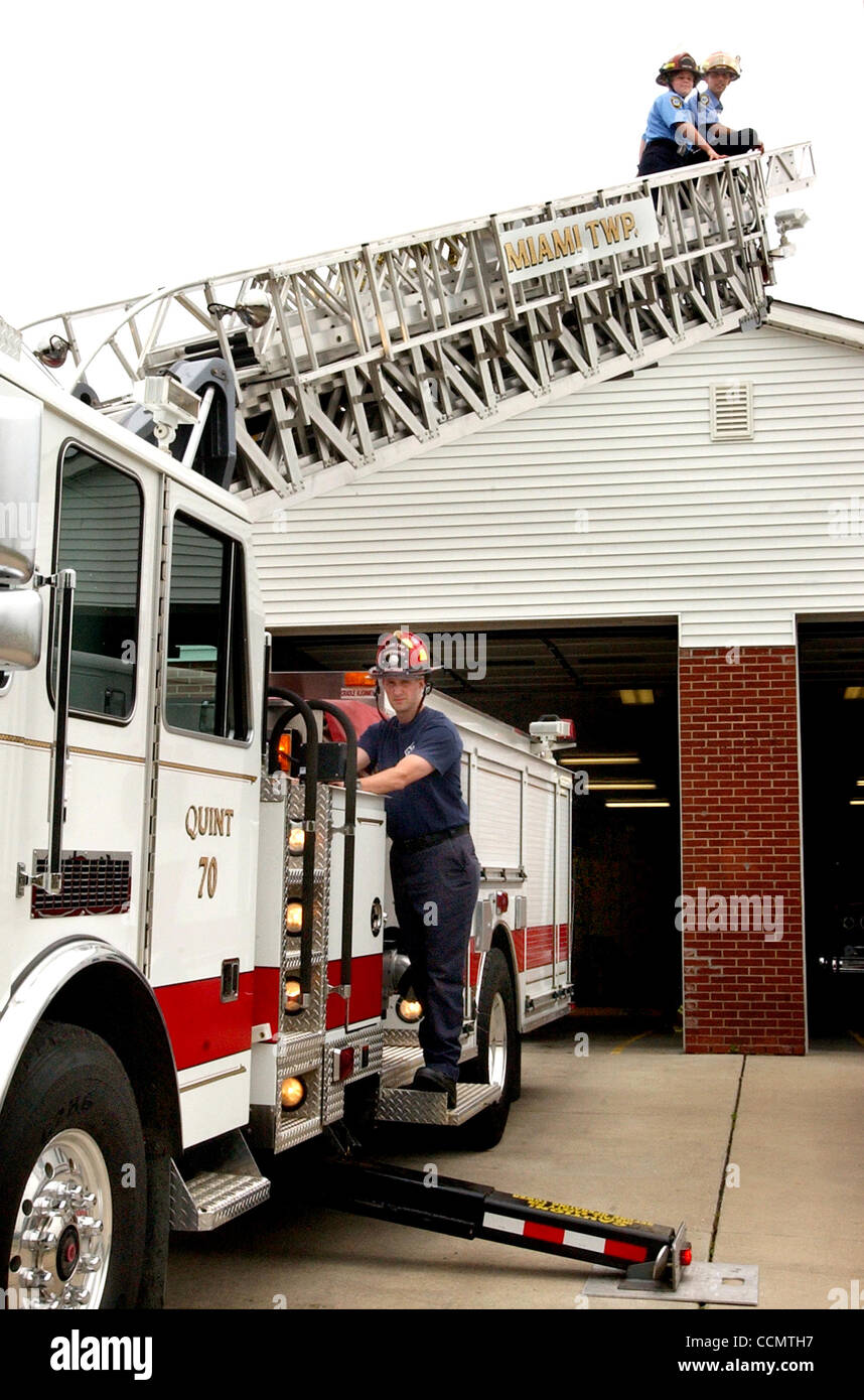 Jun 25, 2004 - Miami Township, Ohio, USA - Miami Township Firefighter STEVE WHITAKER operates the fire truck's controls, as Firefighters DAN HEYOB (R) and AMY GEMMELL (L)  test the 75 ft. aerial ladder.  The truck is dispatched from the township's Shady Lane fire station, one of four that serves the Stock Photo