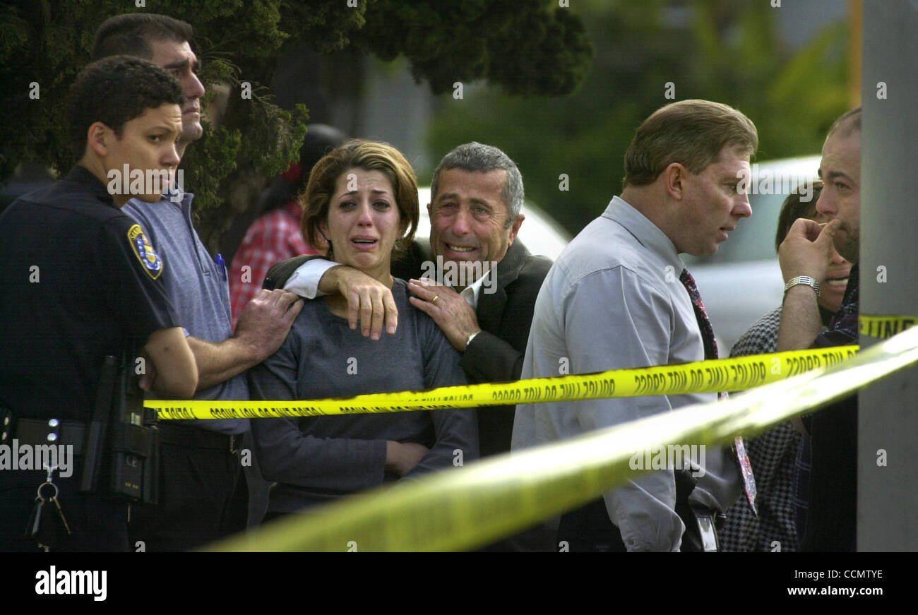 (PUBLISHED 05/02/2003, B-1:1,2,6,7): San Diego Police Department  Officer Michelle Johnson, left, and Sgt. Tony Johnson, facing right, in tie, tried to control relatives of the victim, after they arrived at the scene of  a homicide at Dr. J's Liquor on Logan Avenue, Thursday morning. Stock Photo