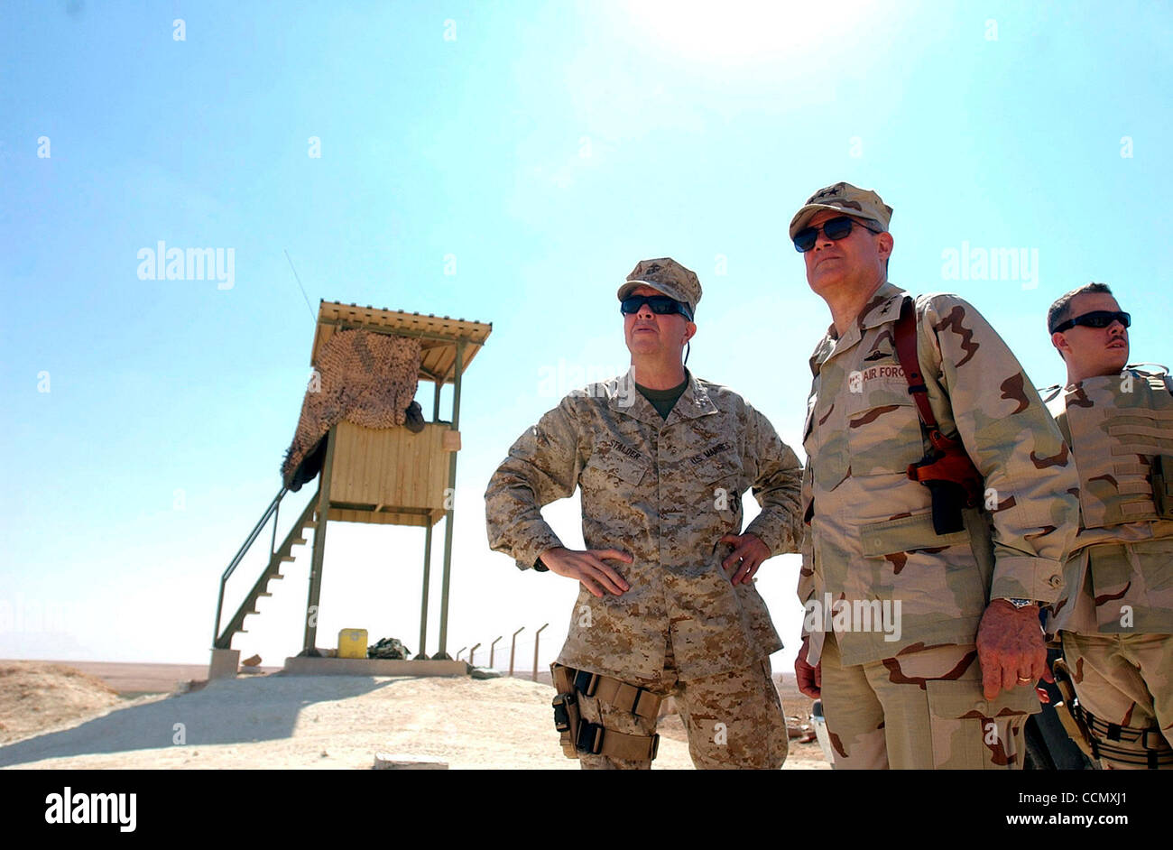 Jul 06, 2004; Baghdad, IRAQ; U.S. Airforce Lt. Gen. LANCE SMITH (C) talks with U.S. Marine Corps Maj. Gen. KEITH STADLER (L) as they look over a section of Al Asad Airbase Tuesday July 6, 2004 as a member of Smith's security detail keeps watch in Iraq. Stock Photo