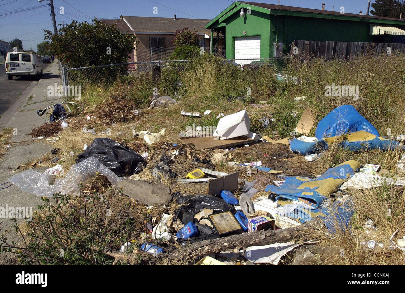Garbage is scattered in an empty lot near the corner of Grove Ave. and