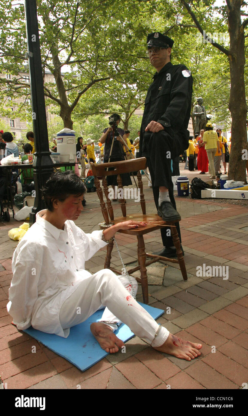 Jul 25, 2004; Boston, Ma, USA; Falun Gong practitioners bring awareness to the persecution & torture they face in China. A practitioner (L) plays the role of victim  & the other (R) Chinese Communist killer in Copley Square. Stock Photo