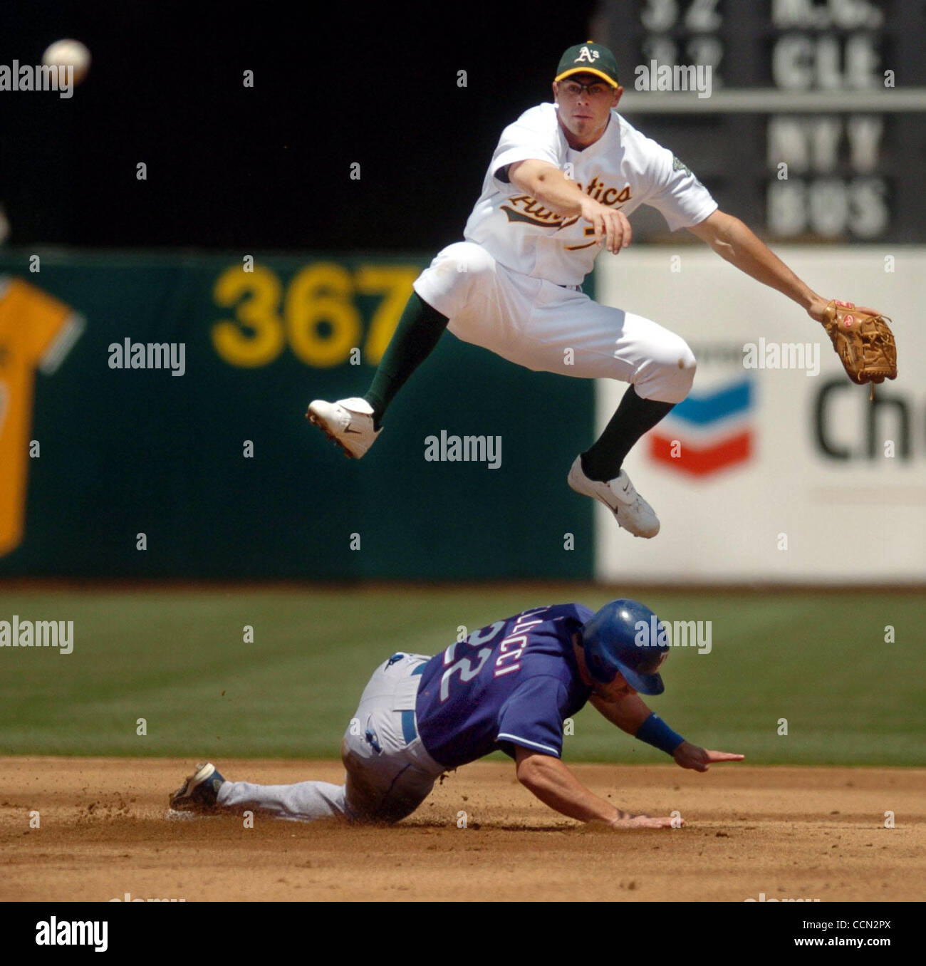 A's shortstop Bobby Crosby (cq) jumps over sliding Texas Ranger David Dellucci (cq) while completing a double play during the 2nd inning of their Major League Baseball game at the Network Associates Coliseum in Oakland, Calif. on Saturday, July 24, 2004. Ranger Michael Young hit into the inning-endi Stock Photo