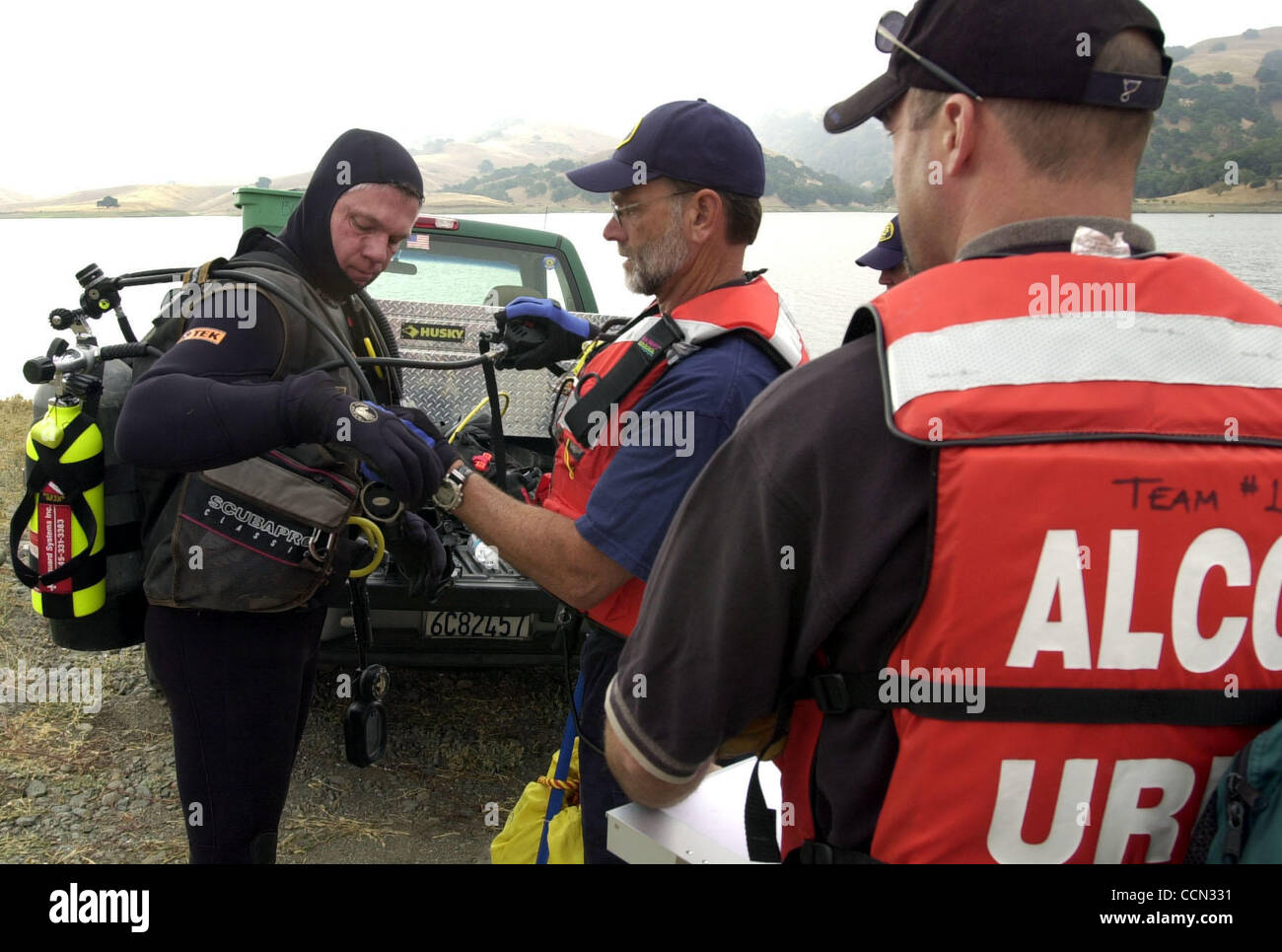 Alameda County Office of Emergency Services Search and Rescue teams hold a training and practice day at the San Antonio Reservoir where tender diver Fred Butler, center, checks the equipment on diver Robert Storer, both of Danville, before starting a diving exercise Saturday, July 24, 2004, in Sunol Stock Photo