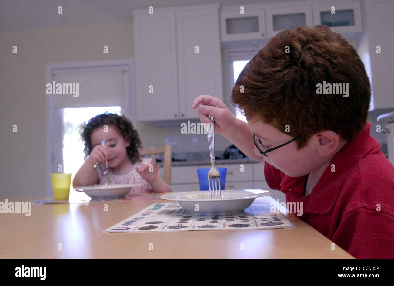 L-R) Melissa Pearl (cq) eats dinner with her big brother David Pearl (cq),  6, at their Walnut Creek, Calif., home on Wednesday July 21, 2004. Pearl's  parents helped get passed a labeling