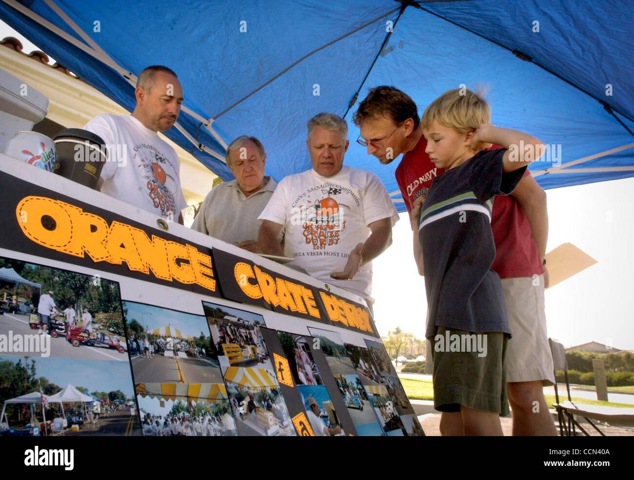 (Published 9/11/2004, B-1:6; UTS1831572; Republished 9/12/2004, B-2:1; UTS1831572) Ray Ramos, inspector, Al Hooper, co-chair, and Lee Roberts, inspector,  left to right, talked with Doug Schenk and his son Noah, 9, about the Orange Crate race cars. Stock Photo