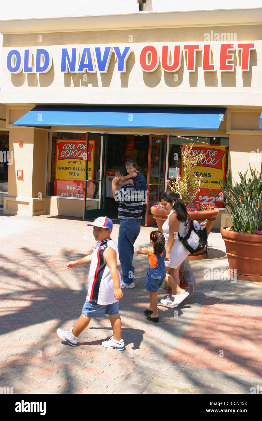 Aug 08, 2004; Lake Elsinore, CA, USA; A Latino Family walk past The Old Navy Outlet store which offers clothing at discount prices. Old Navy is part of Gap, Banana Republic Companies. Shoppers spend thier money and buy discounted clothes at the Outlets. Stock Photo