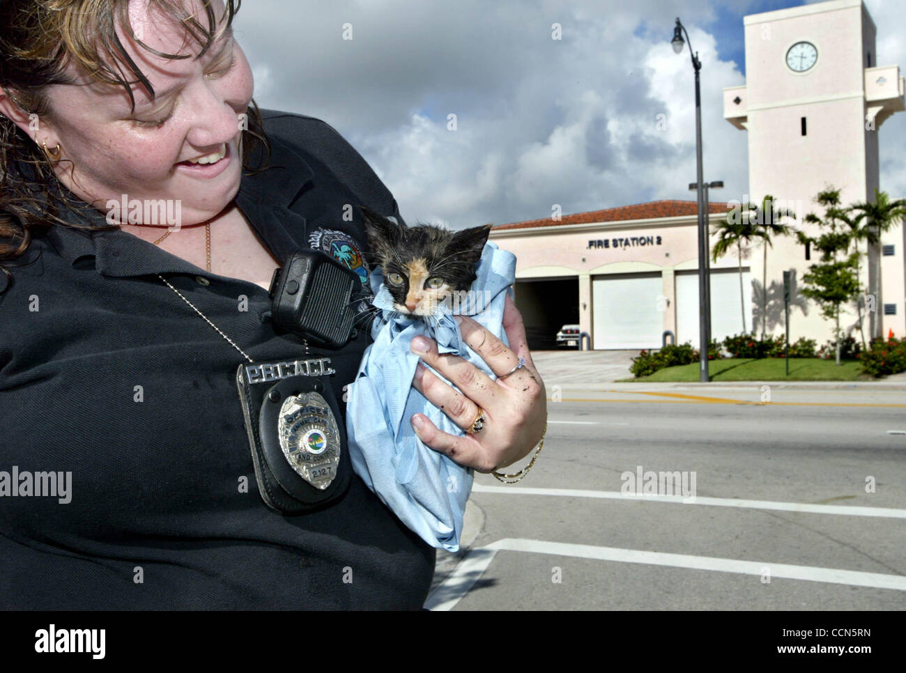 081604 met cat--West Palm Beach--Palm Beach County Animal Care and Control  officerJenny Shook, holds onto a approximately eight week old ferrel cat  after helping rescue it from a storm drain along South