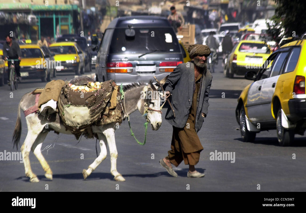 Aug 16, 2004; Kabul, AFGHANISTAN; A Afghan man and his donkey cross a busy street in Kabul, the city has become a strange mix of push carts, donkeys, buses, and taxi drivers with Toyotas. Stock Photo