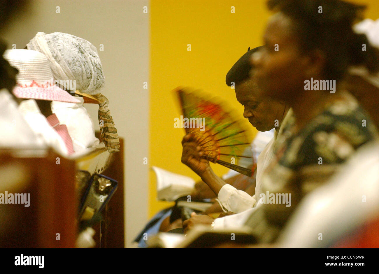 Aug 17, 2004; Miami, FL, USA; A Haitian woman fans herself during a revival service at the Haitian Baptist Church of the Living God in the Little Haiti neighborhood of Miami, FL on Tuesday, August 17, 2004. Stock Photo