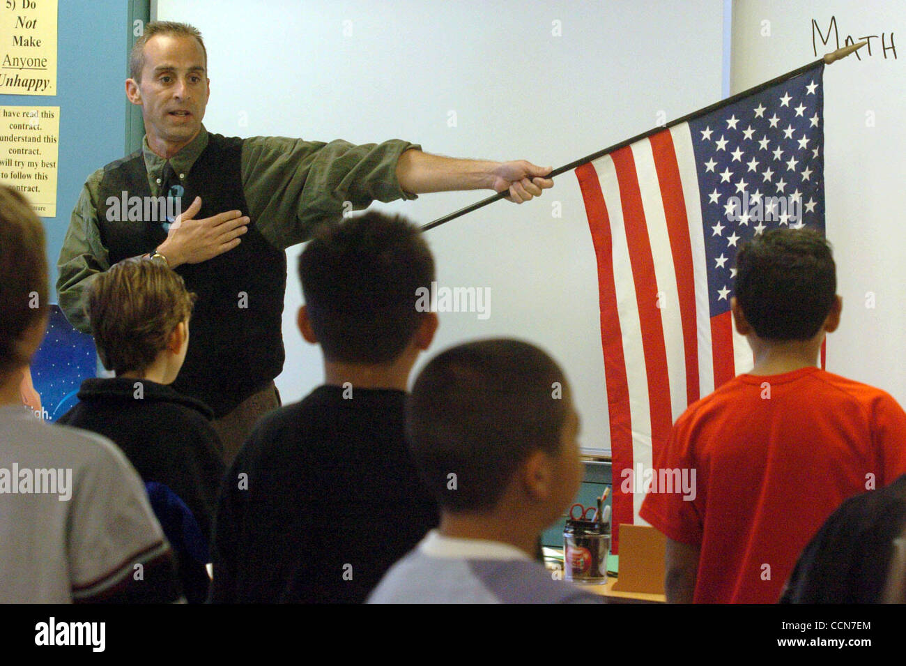 Fourth grade teacher Bill Innes holds the flag during the pledge on the ...