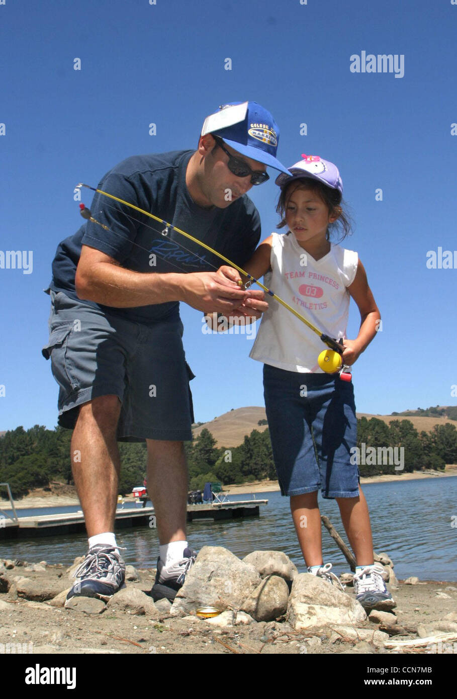 (COMMUNITY PAGE ART) Mike Attard (cq) helps his daughter, Siena Attard (cq)(right), bait her hook while fishing at San Pablo Reservoir in Orinda, Calif. on Wednesday, August 25, 2004. Mike and wife Stefania Attard, from South San Francisco, have been visiting the reservoir for years and now bring th Stock Photo