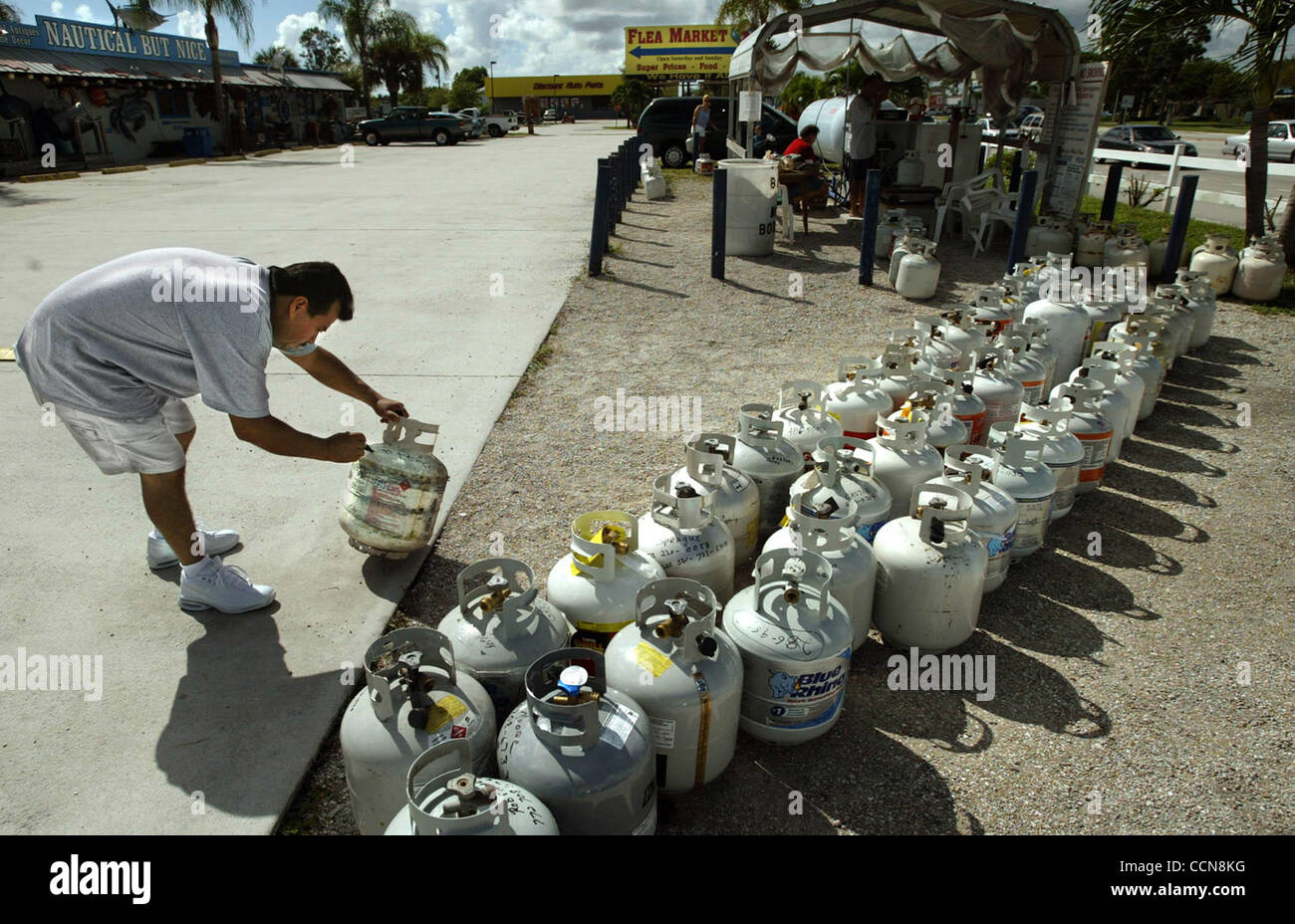 090104 TC MET Stuart...The line formed early wednesday for patrons needing propane tanks filled  in order to be ready for Hurricane Frances.  A propane filling station located in front of the store 'Nautical But Nice' along US 1 in Stuart wednesday morning.  Stuart resident Rufino Perez, left, write Stock Photo