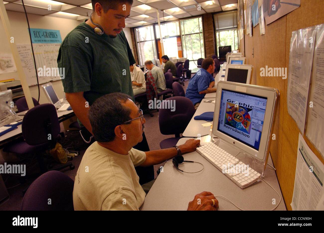 (Published 9/20/2004, B-4, UTS1833230) Students in the computer graphics, Israel (cq) Benitez (cq, let) looks on as Juan Antonio Villanueva (cq, age63, right) works on a Macintosh computer using the Adobe Illustrator program.  Both men are students at the Continuing Education at Educational Cultural Stock Photo