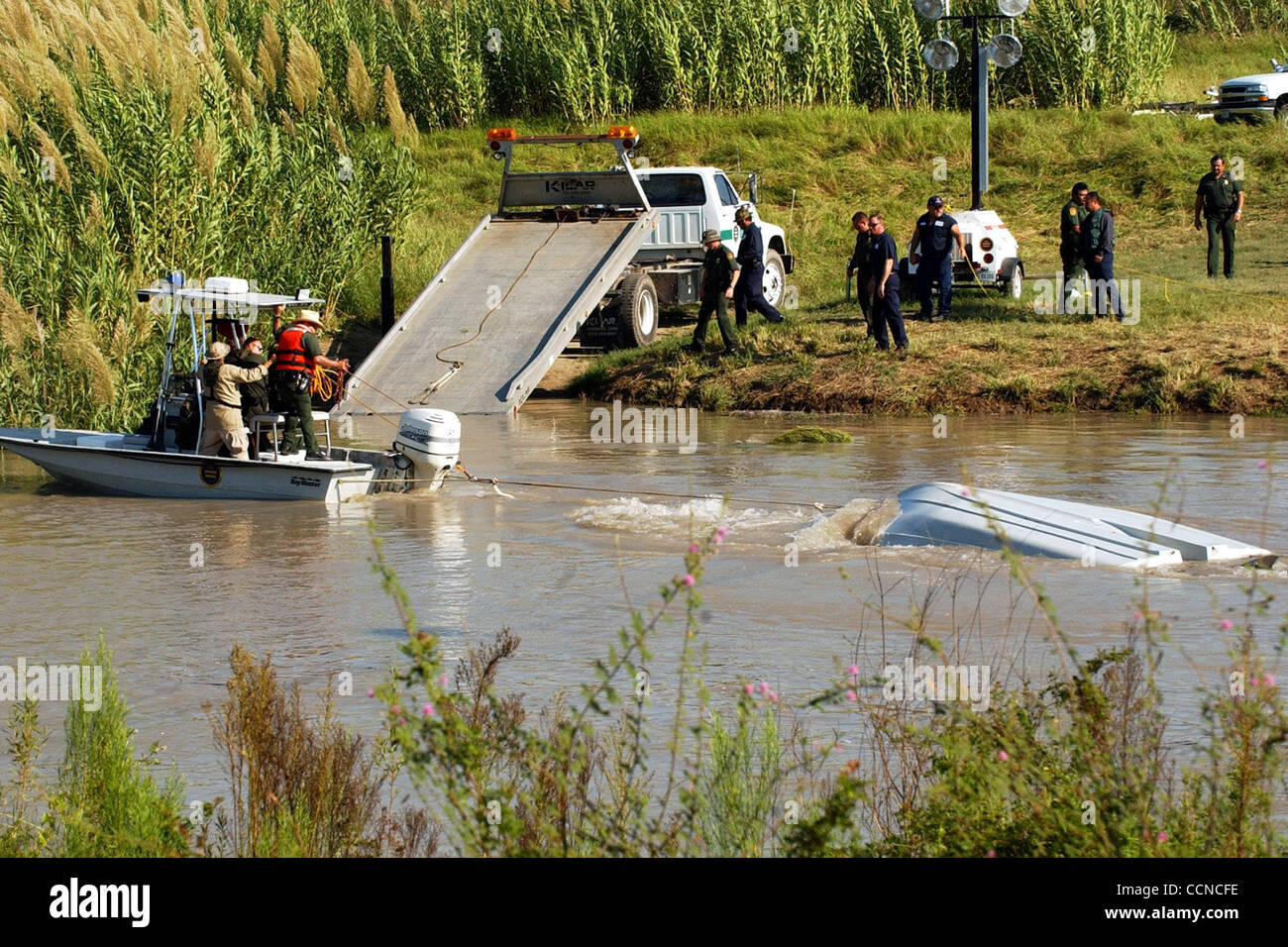 STATE/DAILY/ MISSING AGENTS BOAT: U.S. Border Patrol agents manuver the overturned boat near a waiting tow truck Tuesday morning Sept. 21,2004. The boat was carrying the 3 border patrol agents when it was caught in rough water and capsized killing 2 agents. DELCIA LOPEZ/STAFF Stock Photo