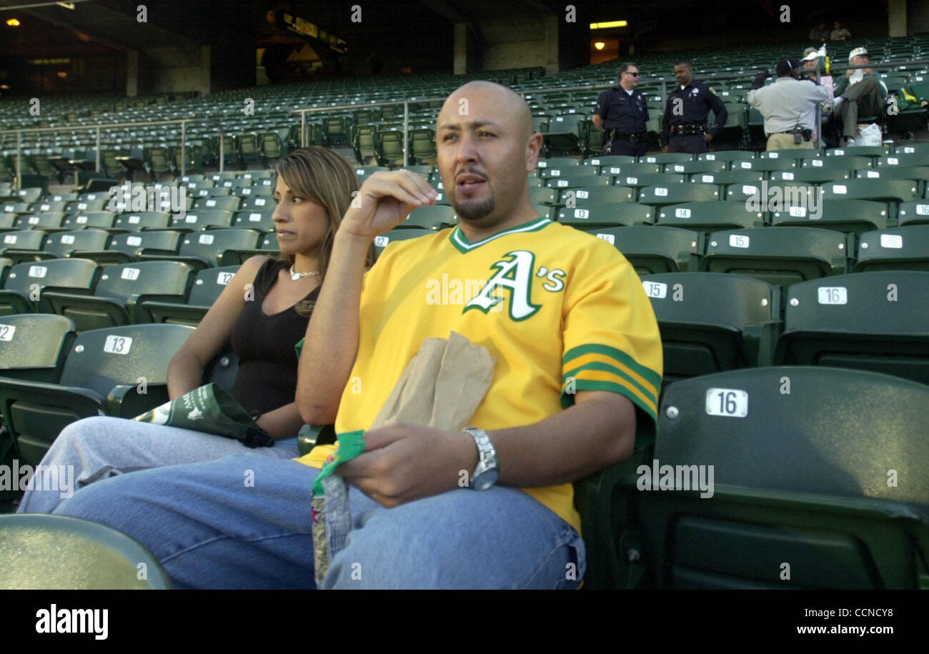 Carlos Carmona and his girlfriend Ana Thome came to watch the game between the Oakland Athletics and the Texas Rangers as Oakland Police and stadium security mill around behind them on Tuesday September 14, 2004 in Oakland, Calif.  Carmona thinks that the heckling is part of baseball.  (Contra Costa Stock Photo