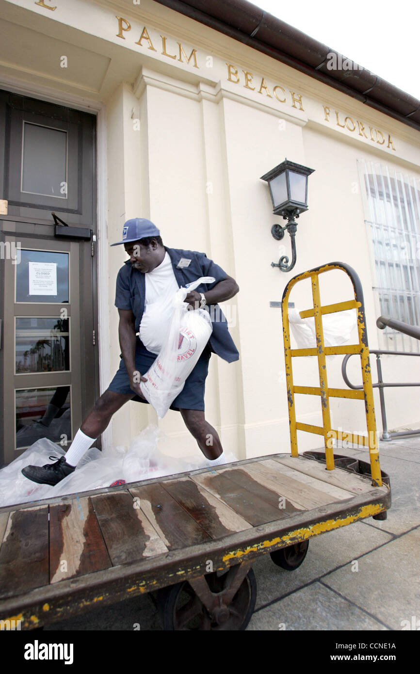 Sep 25, 2004; Palm Beach, Florida, USA; Postal Worker Dannie Harvey places sandbags at on the front door of the Post Office at the corner of South County Road and Royal Palm Way to prepare for Hurricane Jeanne Saturday morning. Stock Photo