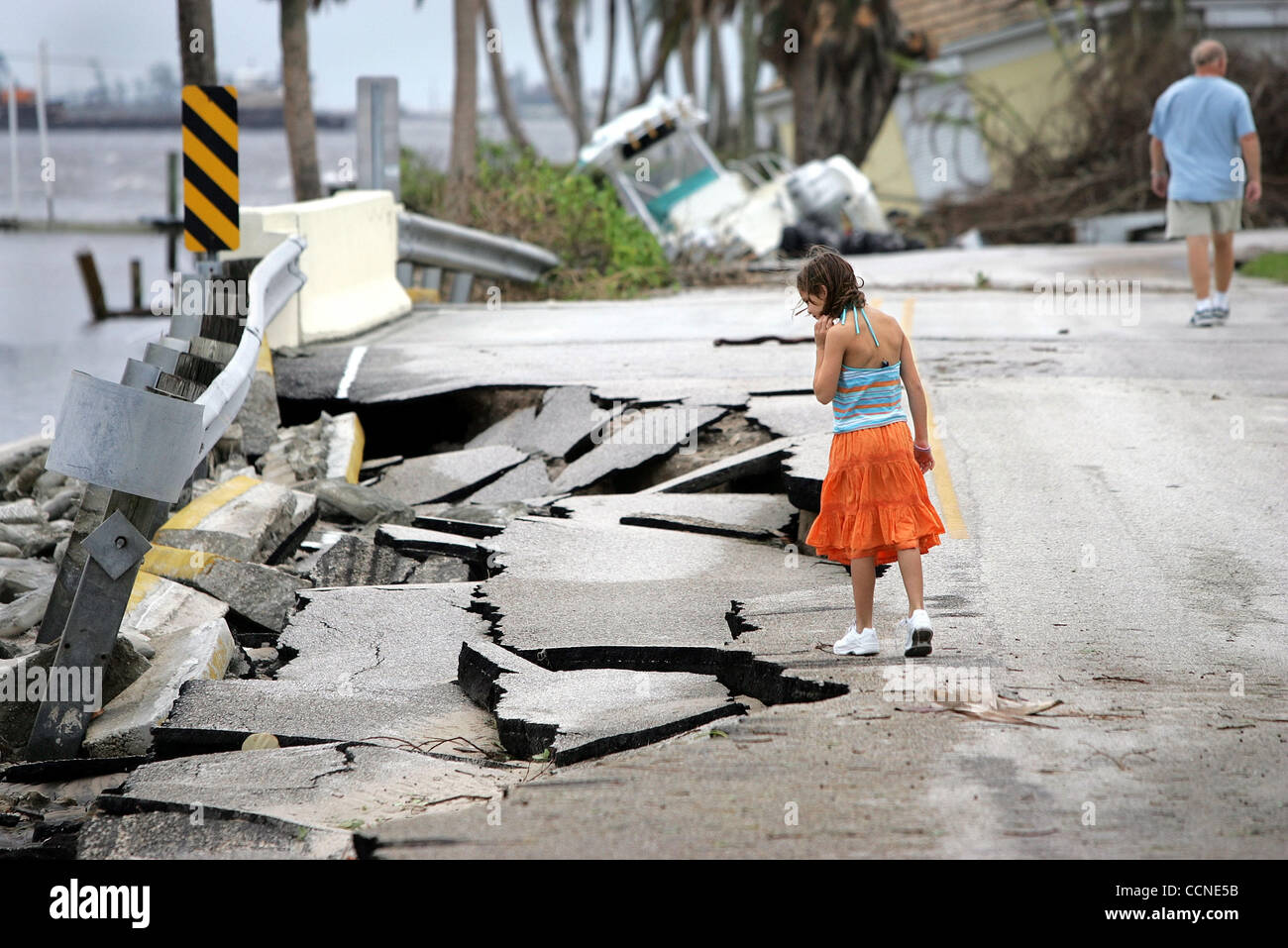 092604 SEWALL'S POINT - STUART, FL - Katie Kinard, 9, looks at asphalt road damage while walking back to her home in The Archipelago neighborhood on Sewall's Point after Hurricane Jeanne hit Sunday.  Katie and her parents Ellen and Jim parked their car at the front of the neighborhood to avoid the r Stock Photo